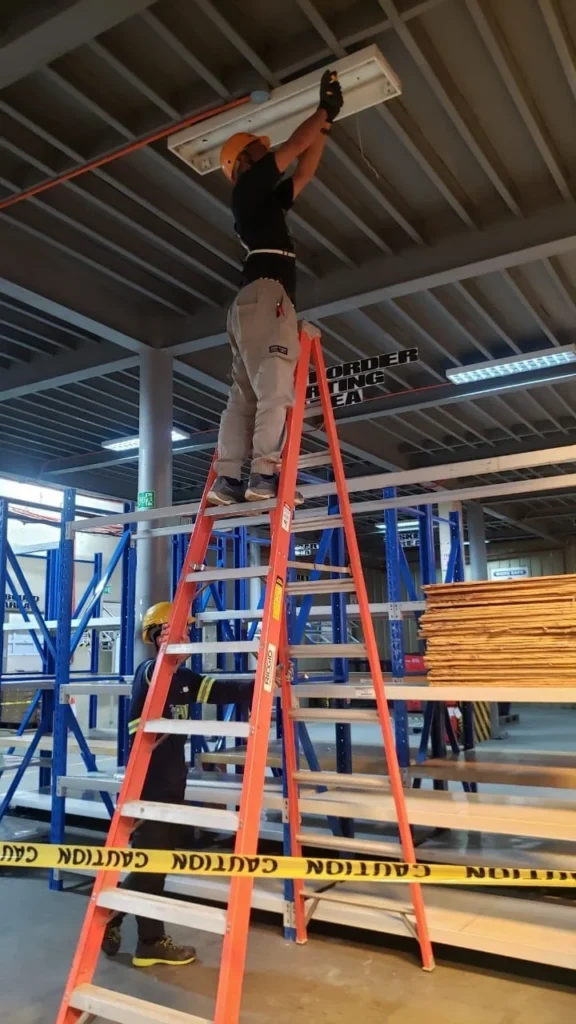 linear-led-ceiling-fixture-installation-step-ladder-warehouse